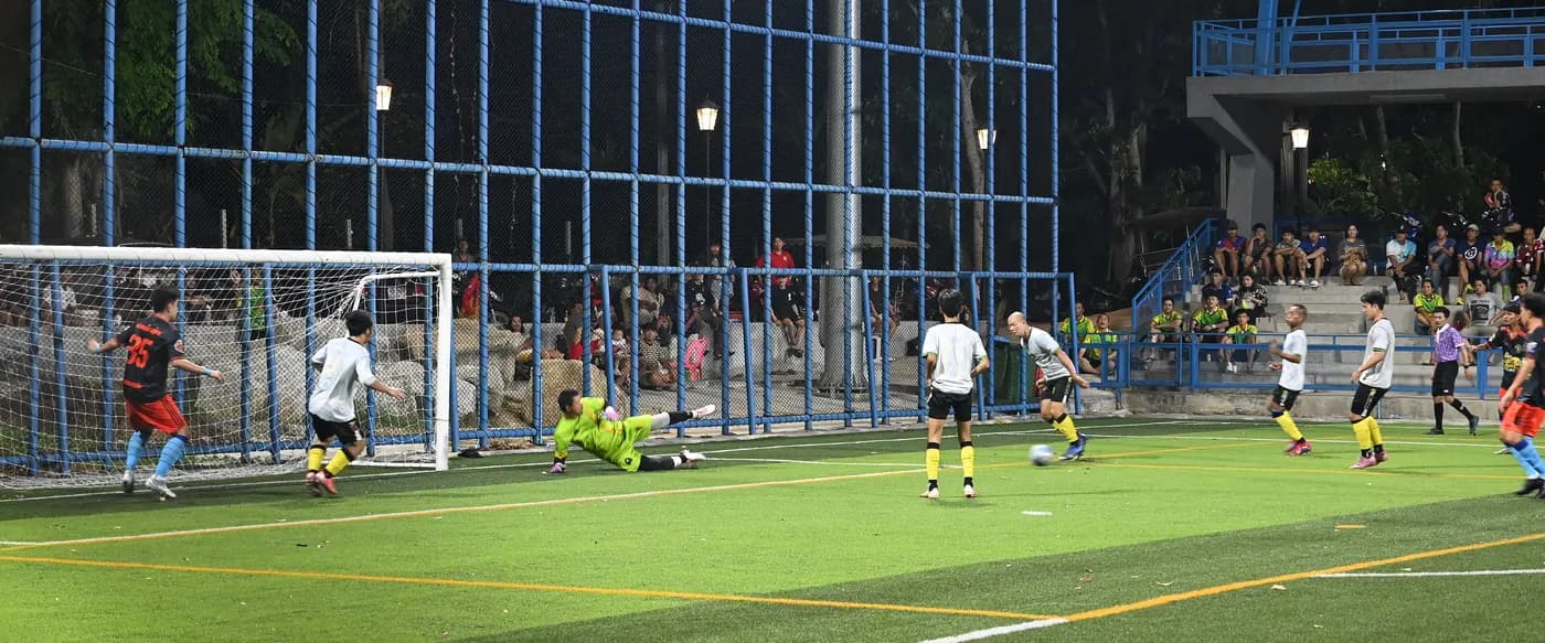 A player striking the ball towards goal during a soccer match